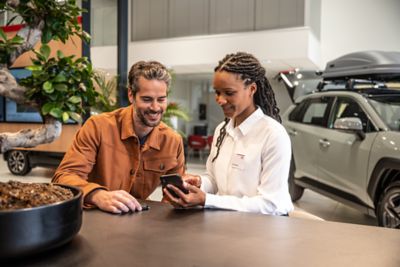 two people looking at a phone inside a Toyota dealership