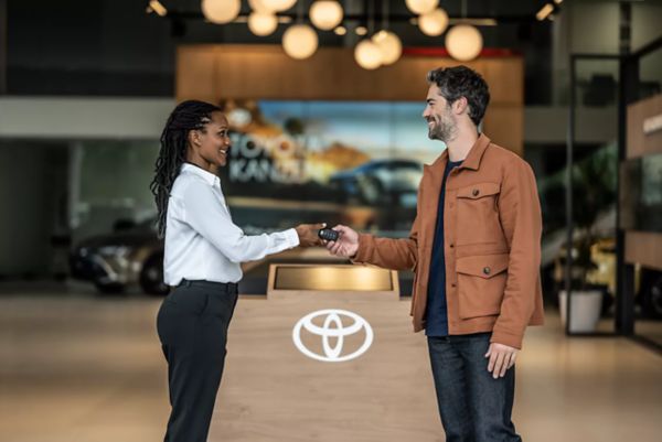 Consultant handing keys to customer at dealership