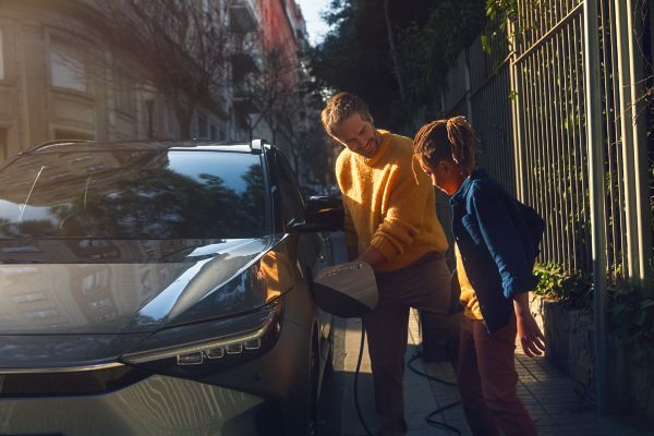 a couple of people looking at a Toyota bZ4X on charge