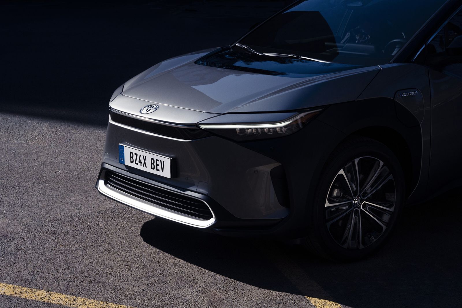 Nahaufnahme der Front des Toyota bZ4X, der geparkt steht und von der Sonne angestrahlt wird.