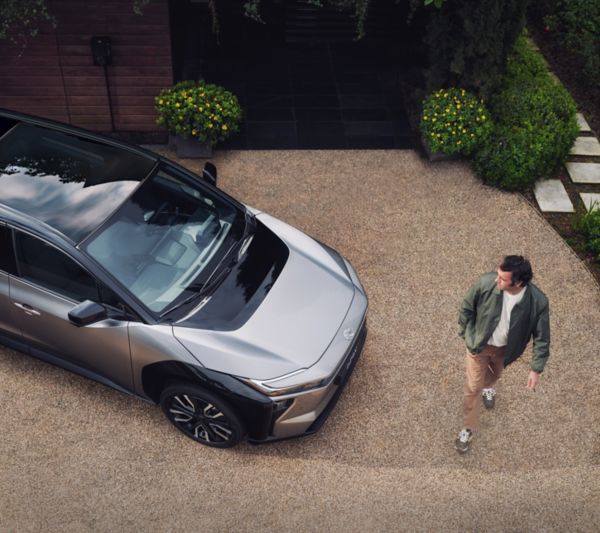 Een man loopt voor een Toyota bZ4x