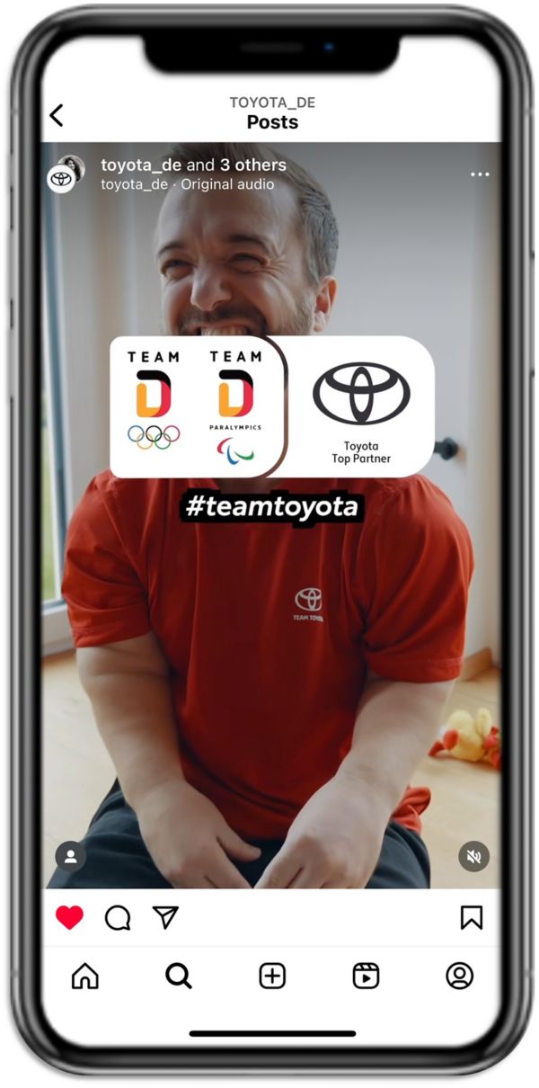 Ein Mann in einem roten T-Shirt lächelt in die Kamera, mit Symbolen für Team Deutschland und Toyota, die über einem Hintergrund eines Social-Media-Posts angezeigt werden.