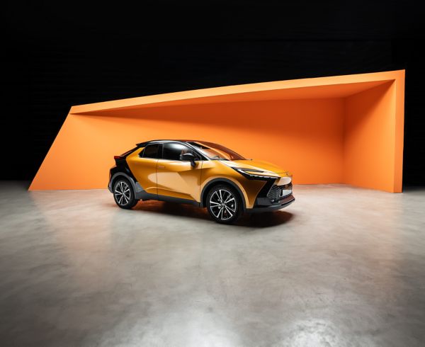 Orange-schwarz lackierter Toyota SUV steht vor einer orangenen Wand und wir hell beleuchtet