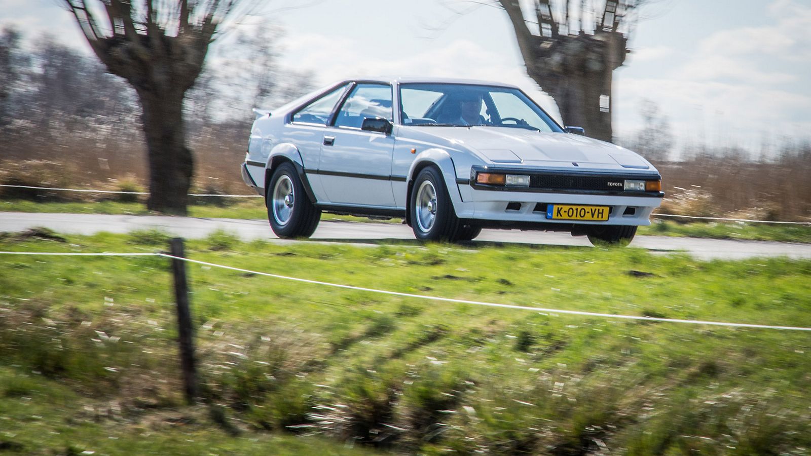 Toyota Celica Supra, exterieur, wit, rechtsvoor, rijdend langs wilgenbomen