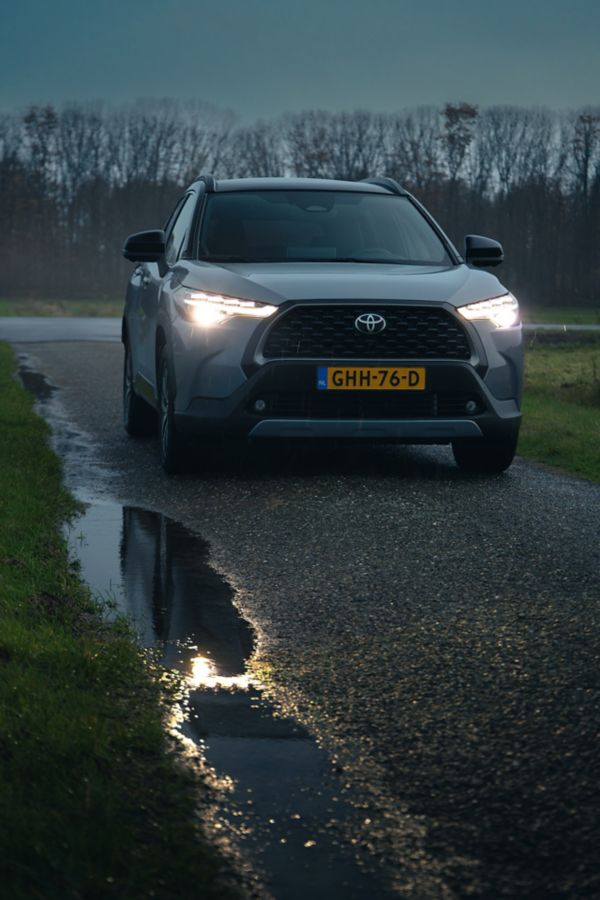 Toyota Corolla Cross schuin vooraanzicht regen schemering