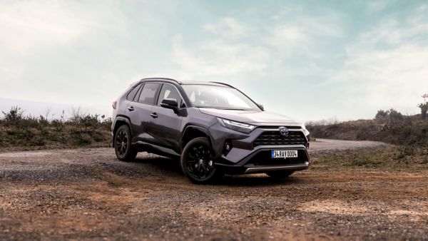 Şehir içinde kavşaktan geçen beyaz RAV4 Hybrid