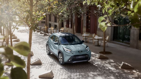 Toyota Aygo X on leafy street