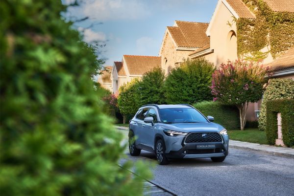 Ein moderner SUV fährt durch eine sonnige Wohnstraße, was den Übergang von geschäftlichen zu privaten Fahrten verdeutlicht, die im österreichischen Fahrtenbuch festgehalten werden müssen.