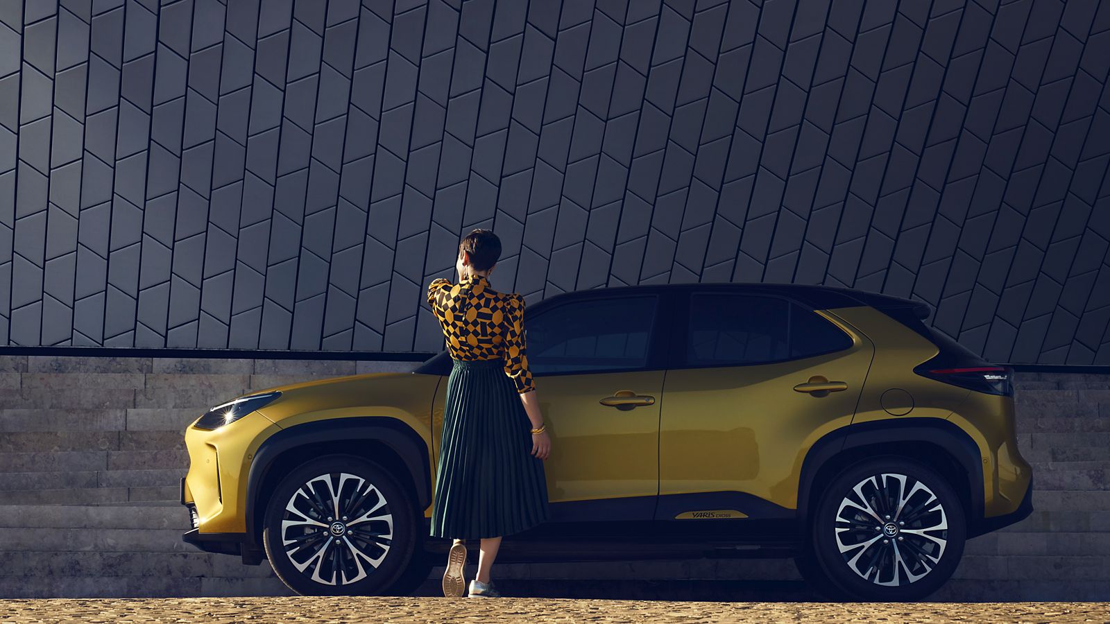 Toyota-Yaris-cross-exterieur-geel-zijkant-vrouw