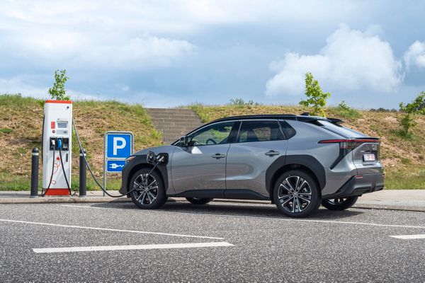 Toyota bZ4X aan openbaar laadpunt parkeerplaats driekwart achteraanzicht