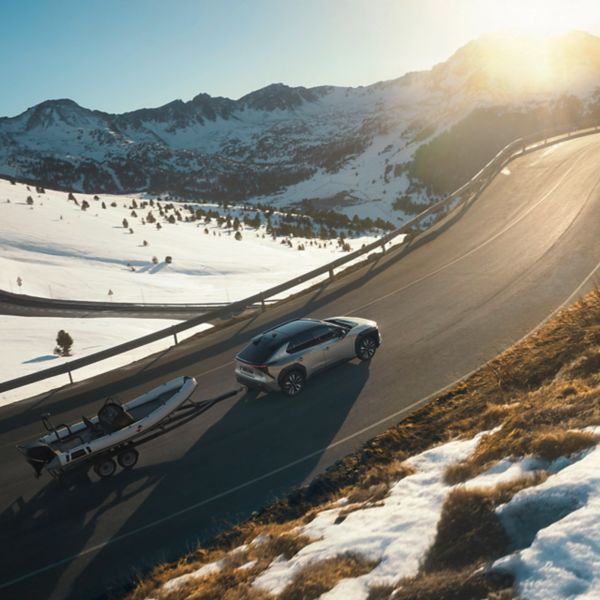 Toyota bZ4X boot aanhanger schuin bovenaanzicht achter winters berglandschap