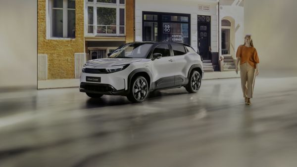 An owner and their Toyota Urban Cruiser at a coffee shop in a city center.