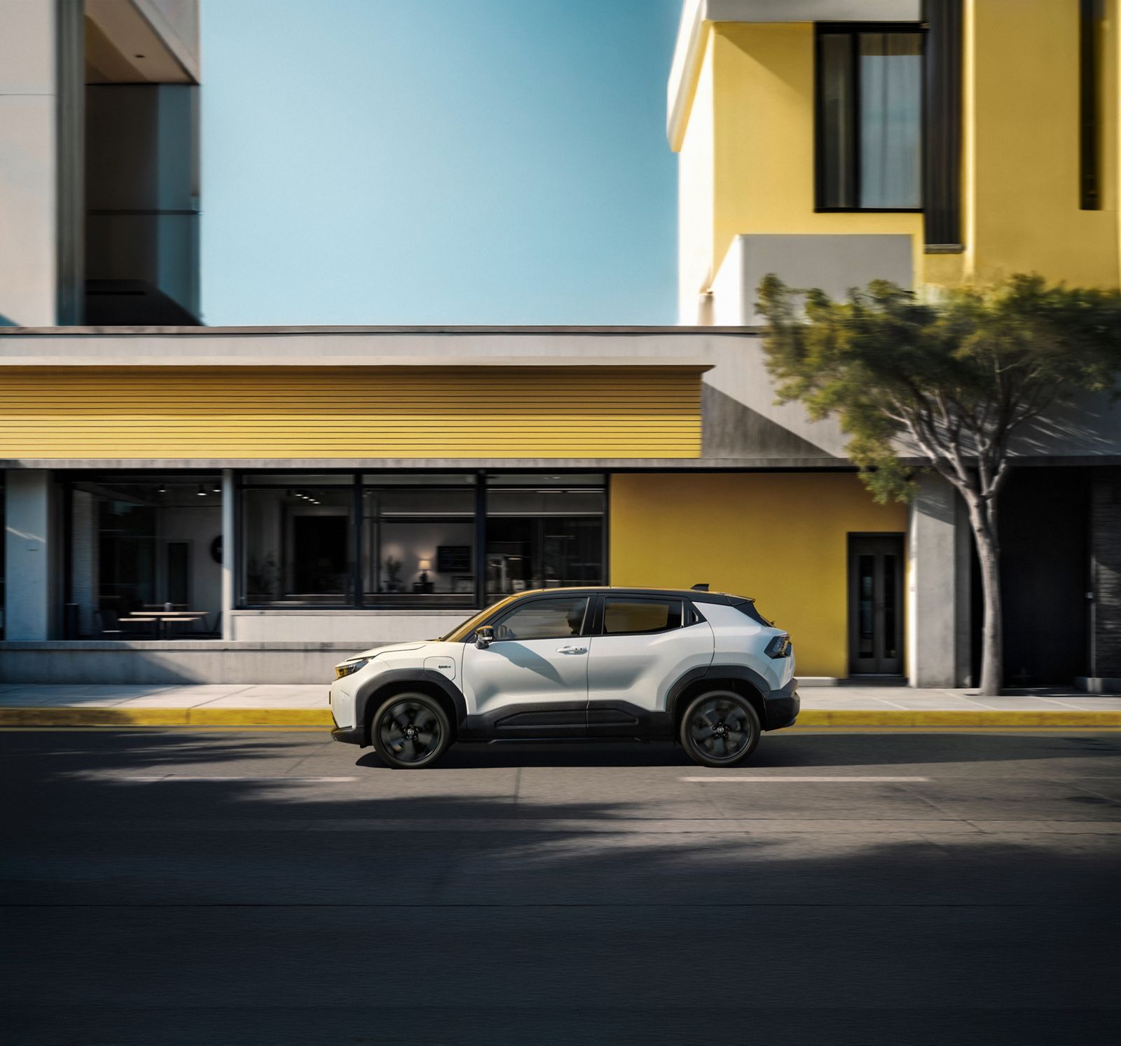 En Toyota Urban Cruiser kjører nedover en solrik bygate