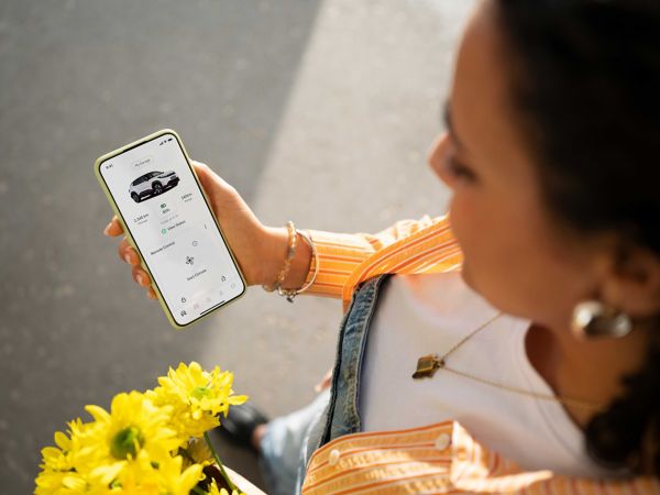 Eine Person in einem Toyota bedient den Multimedia-Bildschirm des Fahrzeugs. Er zeigt die Home-Seite von Apple CarPlay.