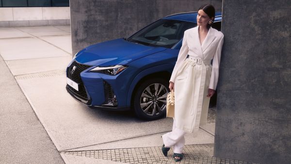 A person stood next to a blue Lexus UX