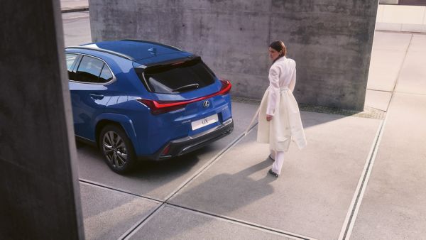 A person stood next to a blue Lexus UX