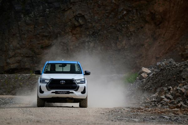 Voorzijde Toyota Hilux waterstof op ruig terrein met stof