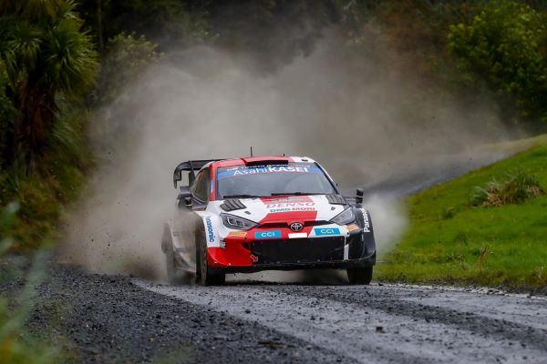 Ein Toyota Rallye-Auto rast über eine Schotterstraße und wirbelt eine Staubwolke auf.