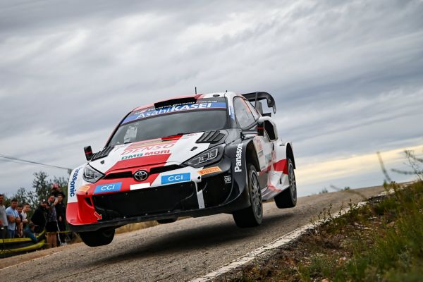 Ein Toyota Rallye-Auto wirbelt eine Staubwolke auf, während es durch das zerklüftete Gelände rast und den Nervenkitzel des Offroad-Rennens zeigt.