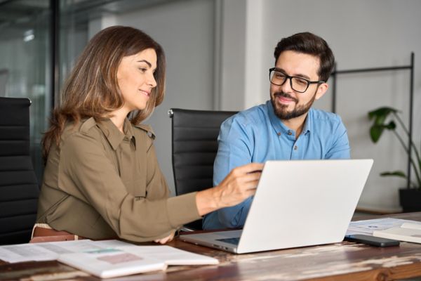 Woman talking to man on laptop