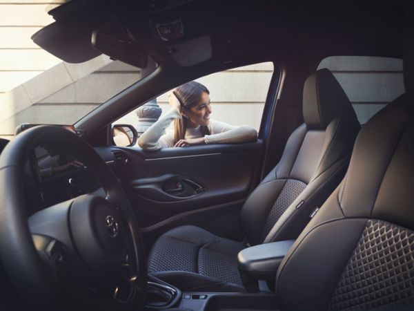 Een persoon kijkt naar binnen bij een Toyota Yaris