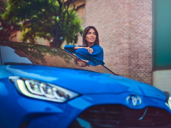 Femme a coté de Yaris bleu