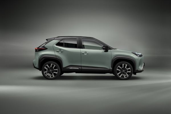 Seitenansicht eines khaki grünen Yaris Cross vor einem neutralen Hintergrund derselben Farbe.