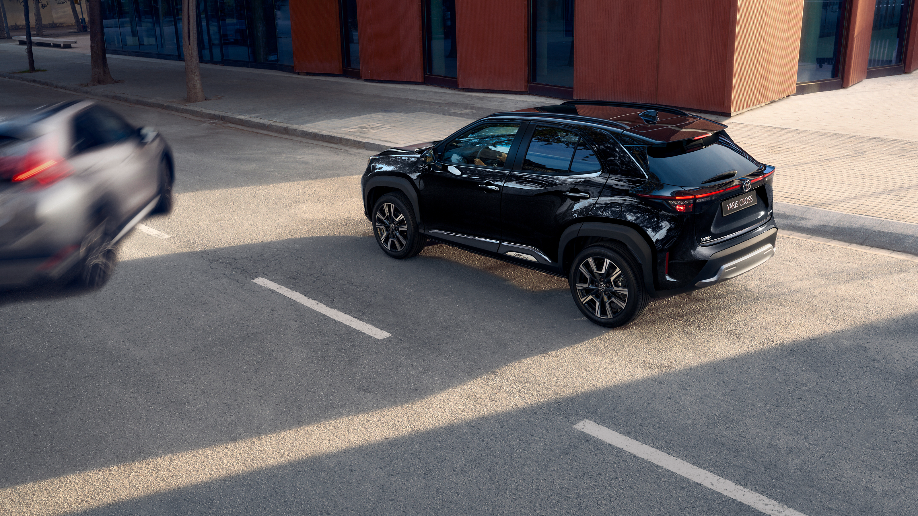 Yaris Cross с хромиран дизайн на кръстовище с второстепенна кола, която се движи към него.