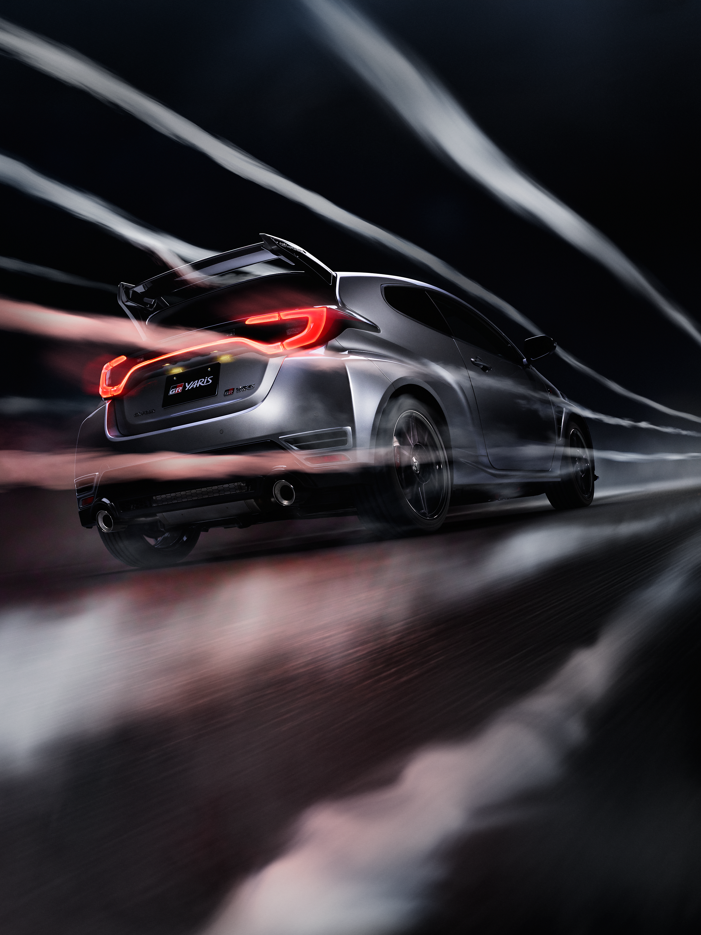 Toyota GR Yaris Aero fährt schnell auf einen schwarzen Hintergrund.