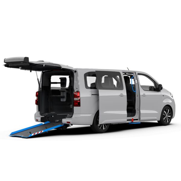 Ein weißer Toyota Proace Verso auf einem weißen Hintergrund. Geöffneter Kofferraum mit einer Rollstuhlrampe.