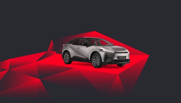 Ein silberner Toyota C-HR vor einem abstrakten Hintergrund mit roten Kacheln
