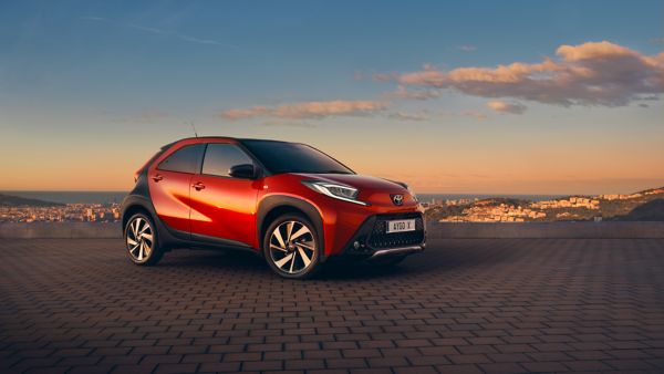 Toyota Aygo X parked behind a landscape view