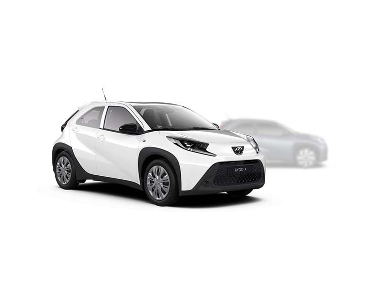 Weißer Toyota Aygo X steht diagonal zur Kamera, im Hintergrund ist unscharf ein heller Aygo X zu erkennen