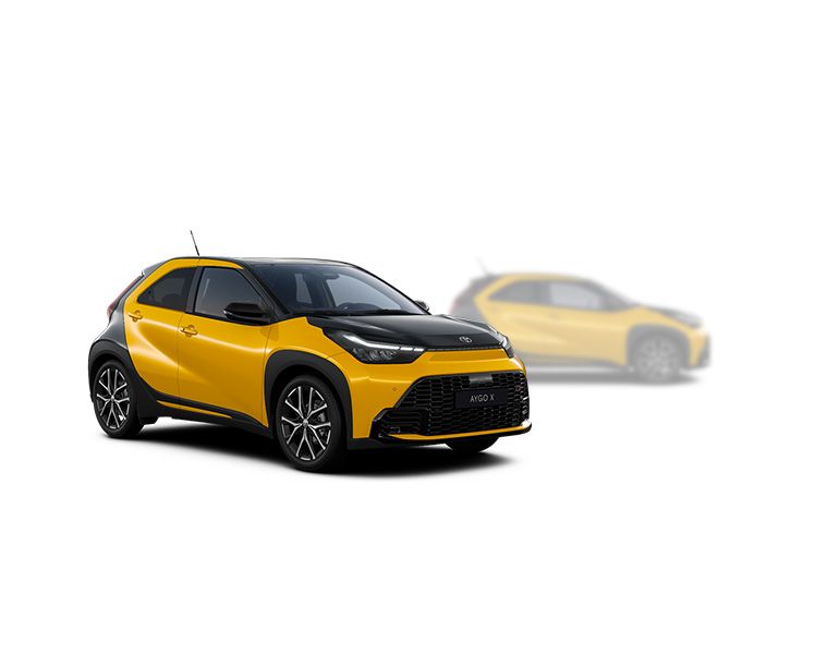 Gelber Toyota Aygo X steht diagonal zur Kamera, im Hintergrund ist unscharf ein heller Aygo X zu erkennen