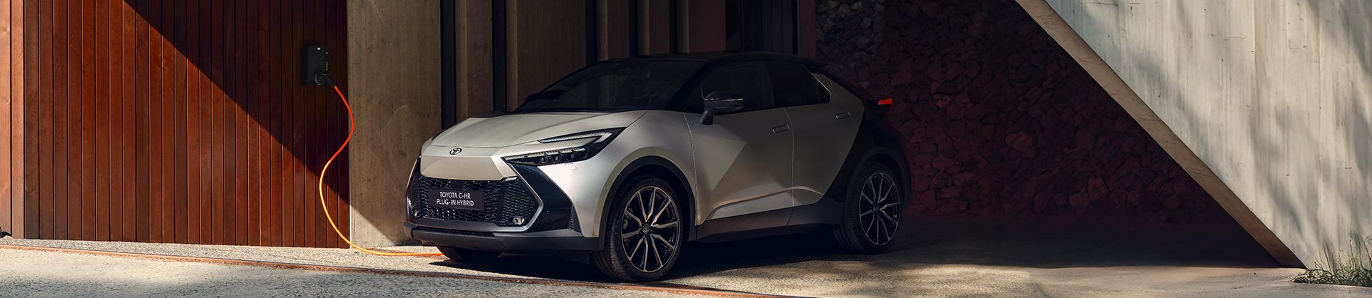 Toyota C-HR Plug-in Hybrid stoi podczas ładowania ze stacji.