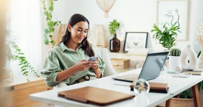 Woman browsing phone at desk