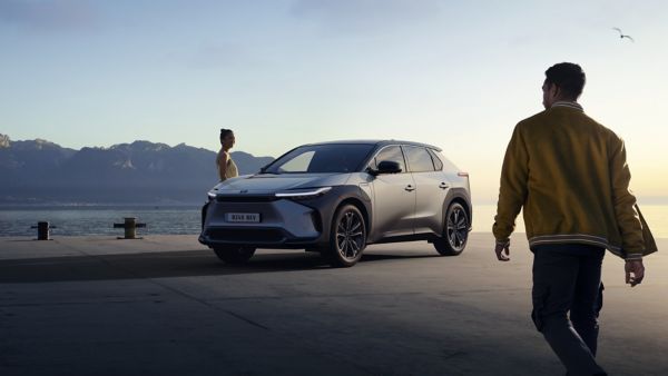 Toyota bZ4X with a woman standing next to it