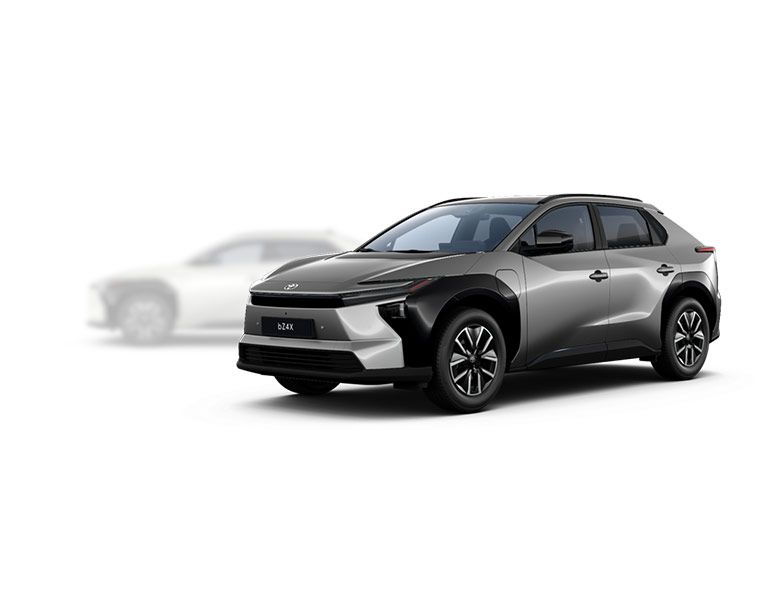 Grauer Toyota bZ4X SUV steht diagonal zur Kamera, im Hintergrund ist ein verschwommener weißer SUV zu sehen.