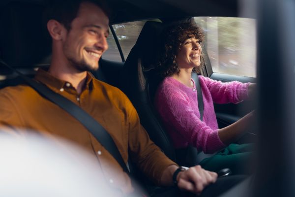 Man and woman smiling in car