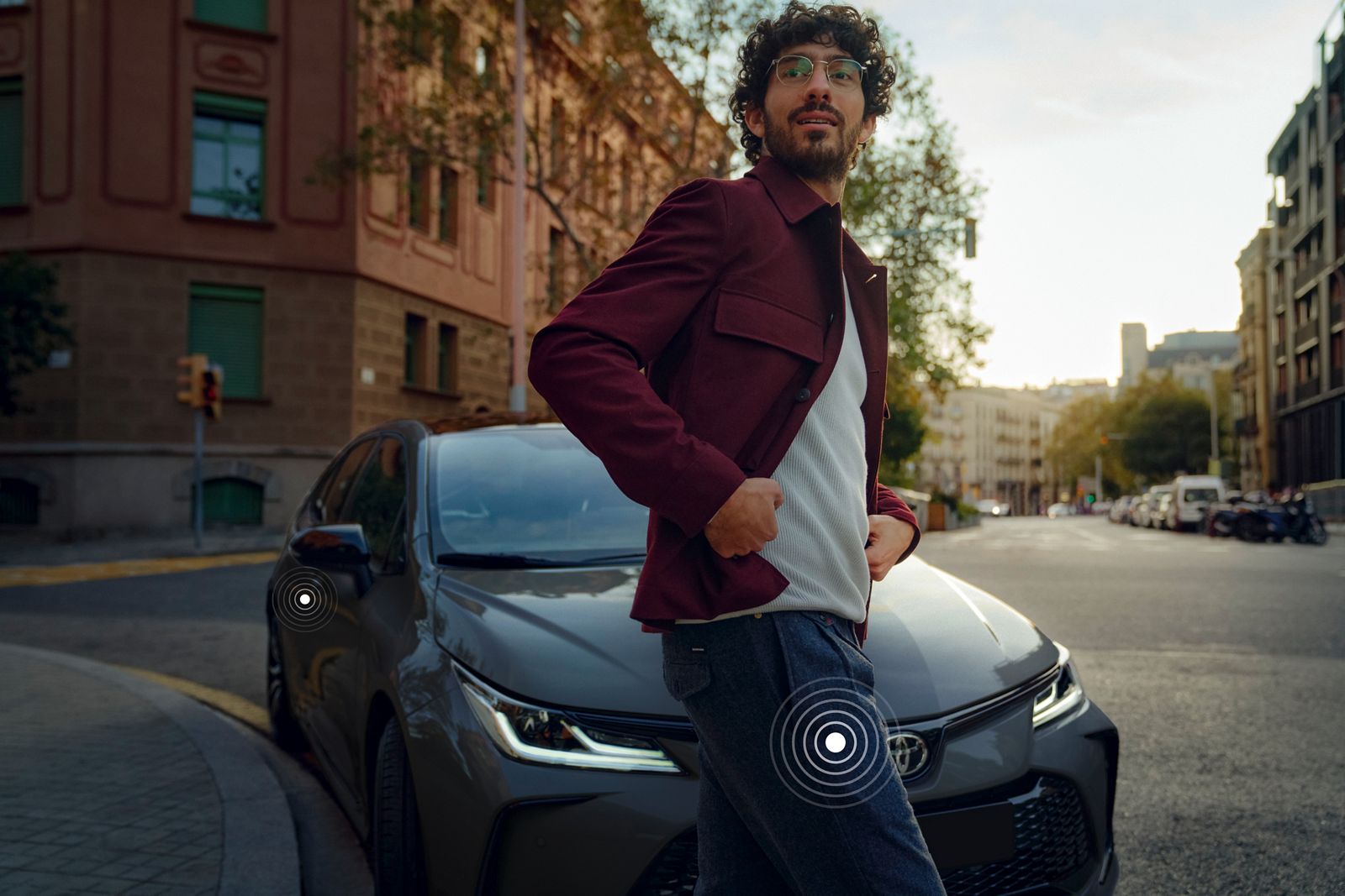 A Toyota Corolla Sedan drives in the city on a bright day