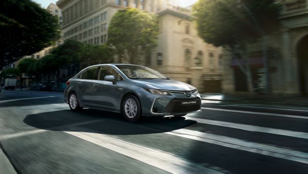 Toyota Corolla Saloon driving down a road