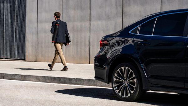 Muž a žena s kyticí ve voze Toyota Cross červené barvy
