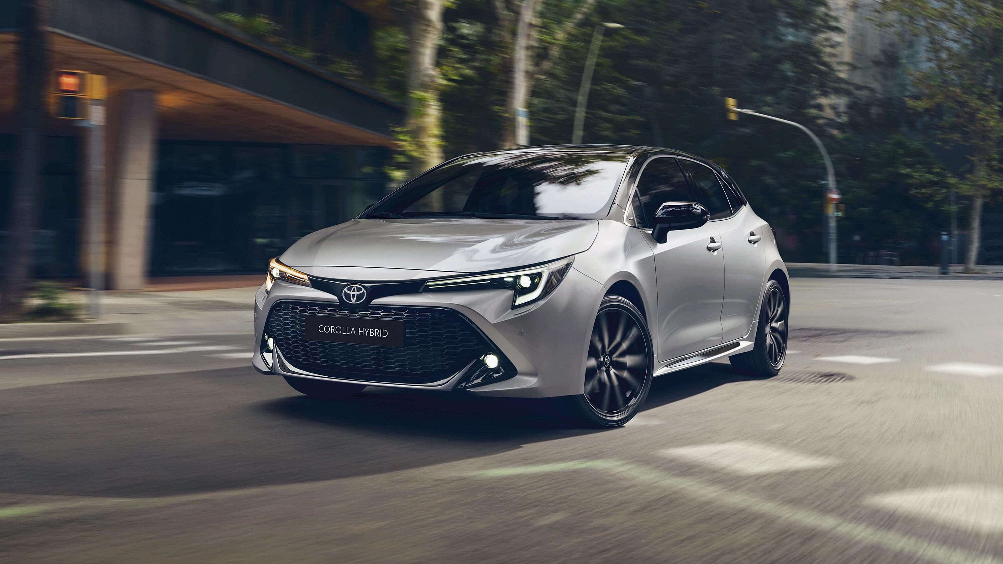 Toyota Corlla fährt in einer städtischen Umgebung. Im Hintergrund sind Bäume und ein Tunnel zu erkennen