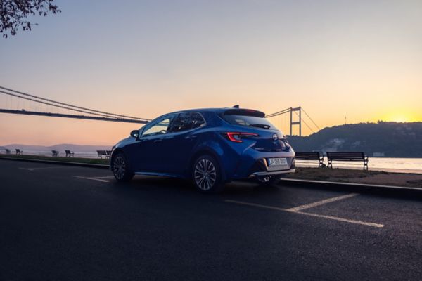 park halindeki Corolla Hatchback Hybrid'in yandan ve arkadan jant ve stop lambalarının görünümü