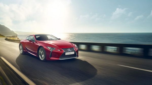 Czerwony Lexus jadący wzdłuż wody