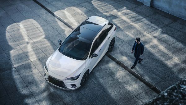 A man walking towards a parked Lexus RX 