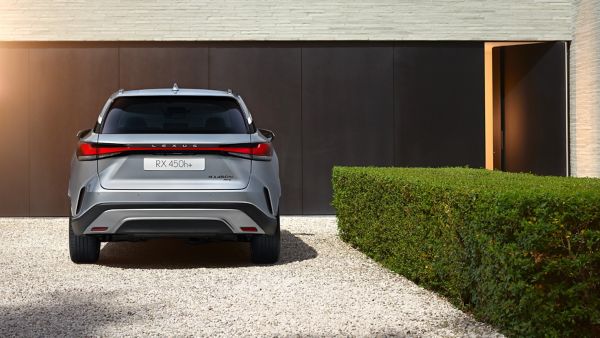 Rear view of a Lexus RX 450h+ parked outside a building