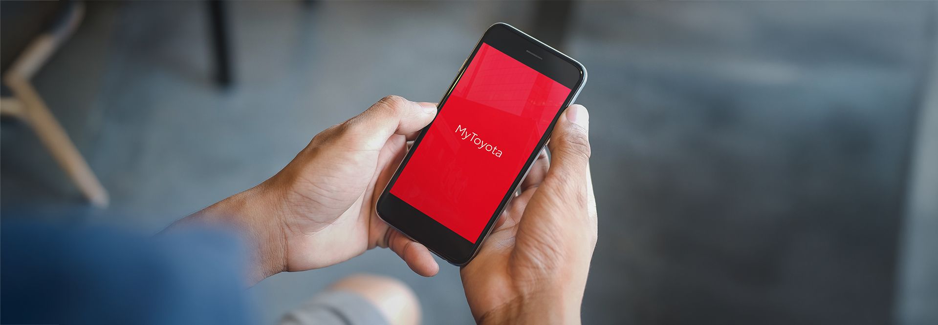 Dłonie trzymające telefon z napisem MyToyota na ekranie