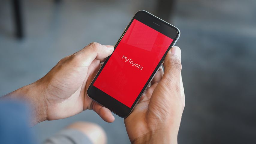 Dłonie trzymające telefon z napisem MyToyota na ekranie