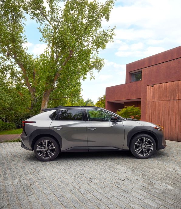 Toyota bZ4X stoi przed posesją.